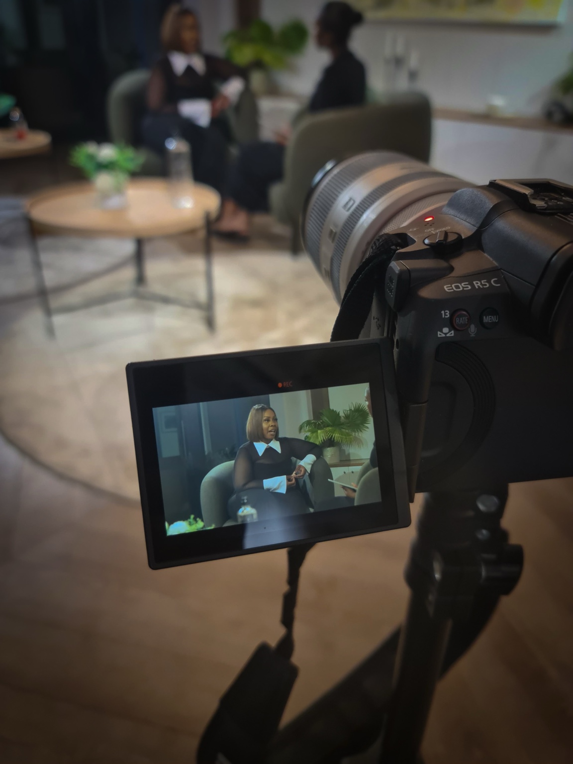 Andrea in conversation during filming, with the camera and its screen visible in the foreground
